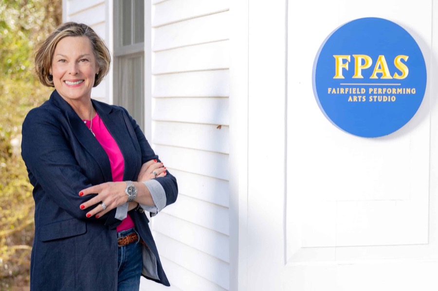 Jennifer Kenny, founder and artistic director, outside the Fairfield Performing Arts Studio beside its blue and gold sign
